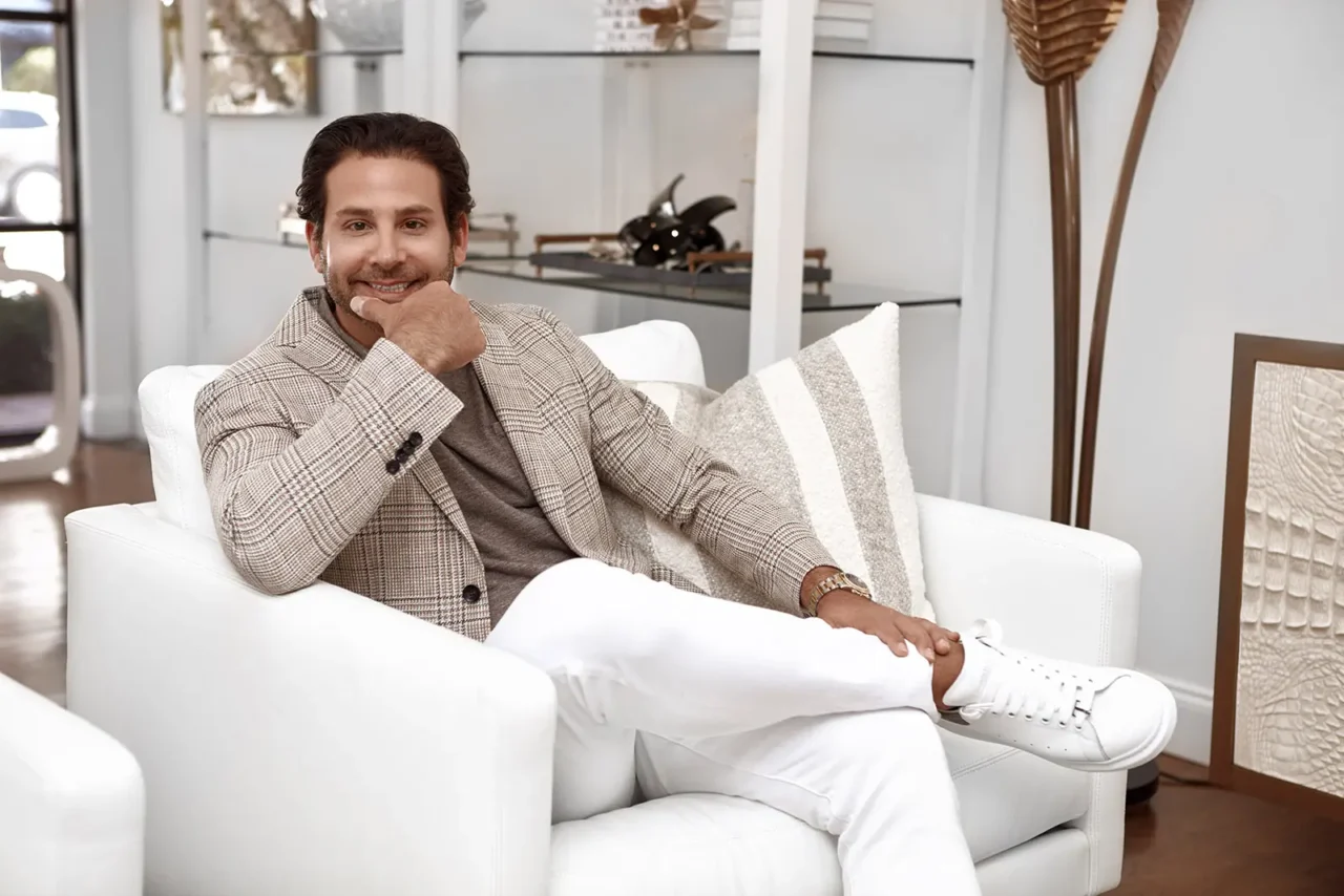 Man in a beige checkered blazer and white pants