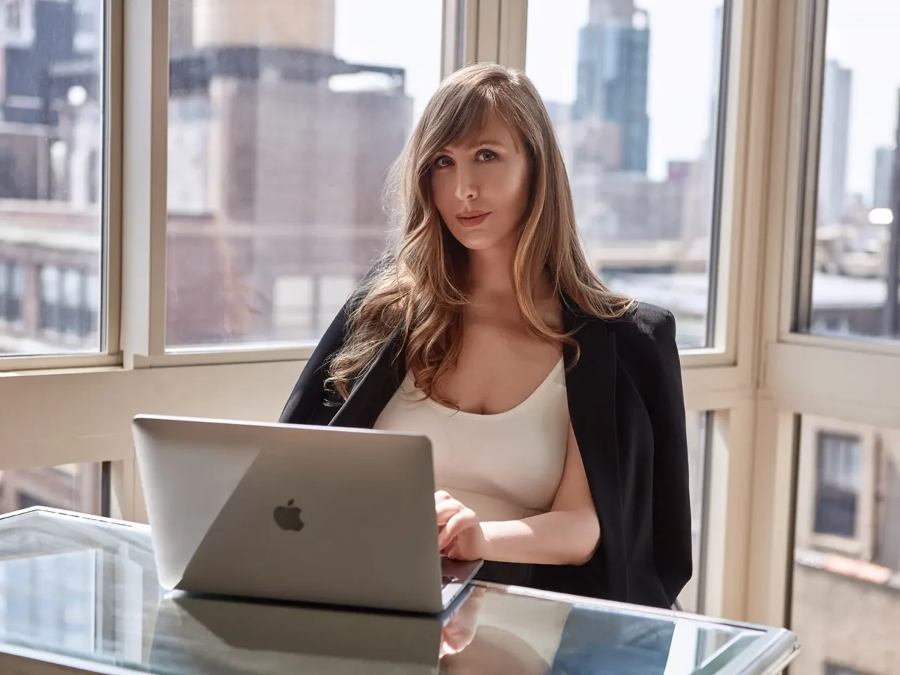 Businesswoman working on a laptop in a sunlit office